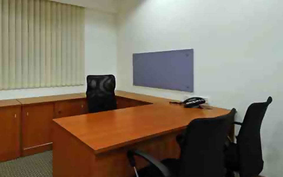 Private cabin with an L-shaped cherry laminate desk, low credenza, fabric pinboard and vertical blinds