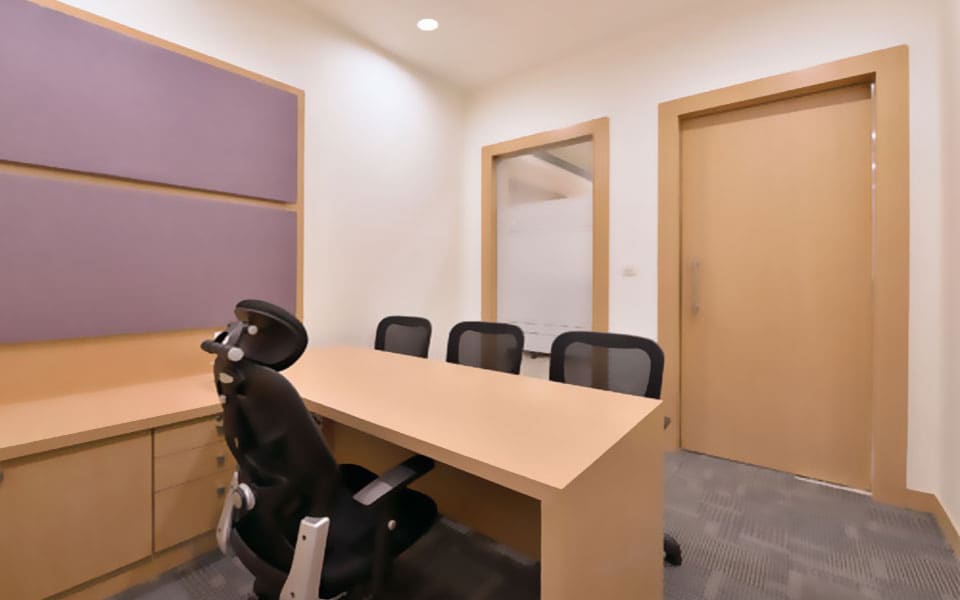 Cabin with a maple desk and drawer unit, aubergine upholstered wall panels and a glazed vision panel