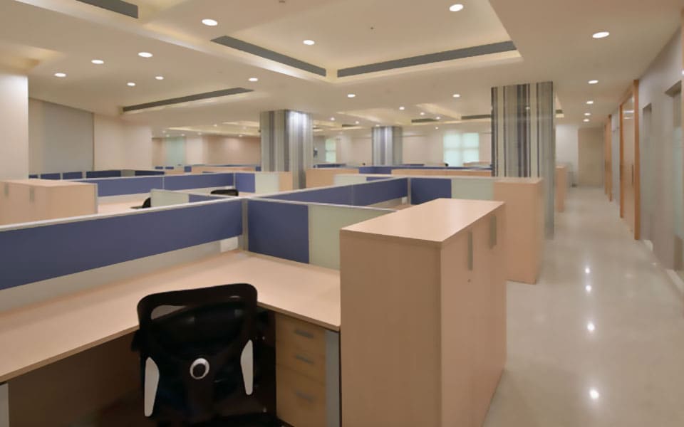 Open-plan cubicles beside a polished corridor, with beech storage units, blue screens and a coffered ceiling